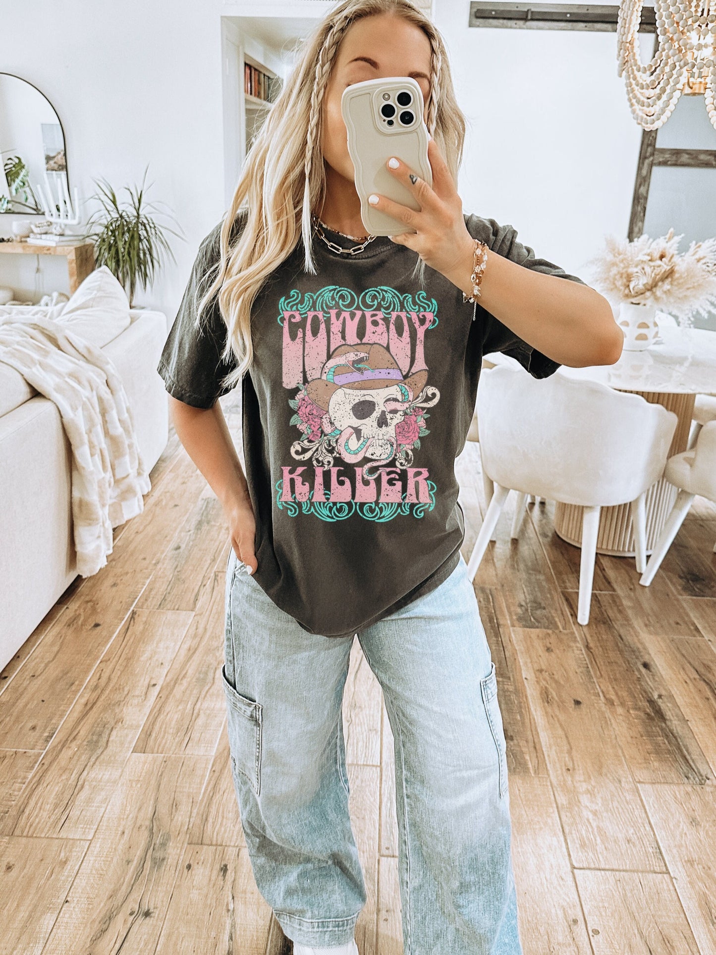 Oversized Comfort Colors tshirt in a dark grey shade called pepper. Model is wearing one size up for a large fit. Graphic design is of a pastel cowboy skull with a snake wrapped around and roses.