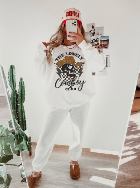 Oversized, long sleeve crew neck sweatshirt featuring a distressed cowboy skull graphic with a western aesthetic in neutral shades.